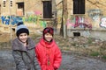 Bulgarian girl and a Gypsy boy play together in front of ruined old residential building